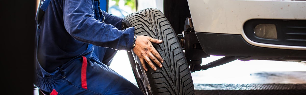 Mechanic putting a tire on a vehicle